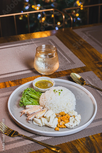 Boiled chicken rice mixed with crab meat on a wooden table