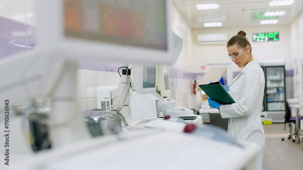 A female scientist controls the operation of devices for laboratory research. Modern laboratory technologies. Medical research centrifuge. A female scientist controls the operation of devices for laboratory research. Modern laboratory technologies. Medical research centrifuge.
