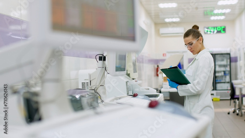 A female scientist controls the operation of devices for laboratory research. Modern laboratory technologies. Medical research centrifuge.