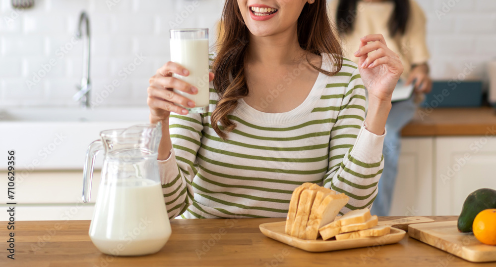 Portrait of beauty healthy asian woman smiling and having protein breakfast drinking and hold glasses of milk of fresh milk, nutrition,calcium and vitamin,dairy product in kitchen at home.Diet concept Portrait of beauty healthy asian woman smiling and having protein breakfast drinking and hold glasses of milk of fresh milk, nutrition,calcium and vitamin,dairy product in kitchen at home.Diet concept