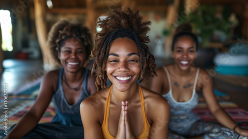 Three friends radiate joy during a yoga practice, their shared laughter and relaxed poses embodying a spirit of camaraderie and wellbeing.