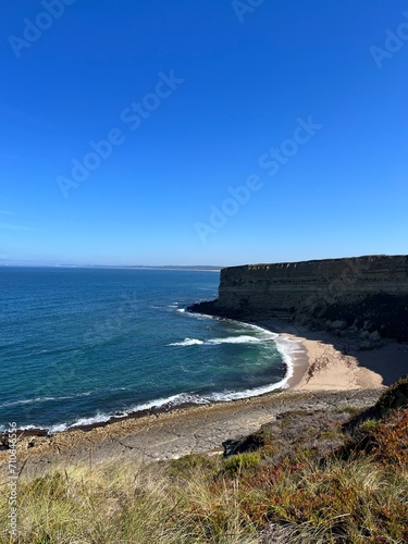 Ocean coast, clear blue sky, blue horizon, natural colors, no people