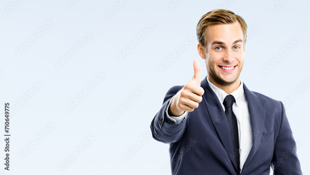 Happy businessman in suit, white shirt, necktie show thumb big finger up, like, agree hand sign gesture, isolated on grey wall background. Excited business man at studio image. Success ad concept. Happy businessman in suit, white shirt, necktie show thumb big finger up, like, agree hand sign gesture, isolated on grey wall background. Excited business man at studio image. Success ad concept.