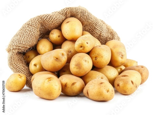 Fresh potatoes spilling out of a rustic burlap sack. The potatoes, with their smooth, lightly speckled skins, vary in size and are in natural, earthy tones.