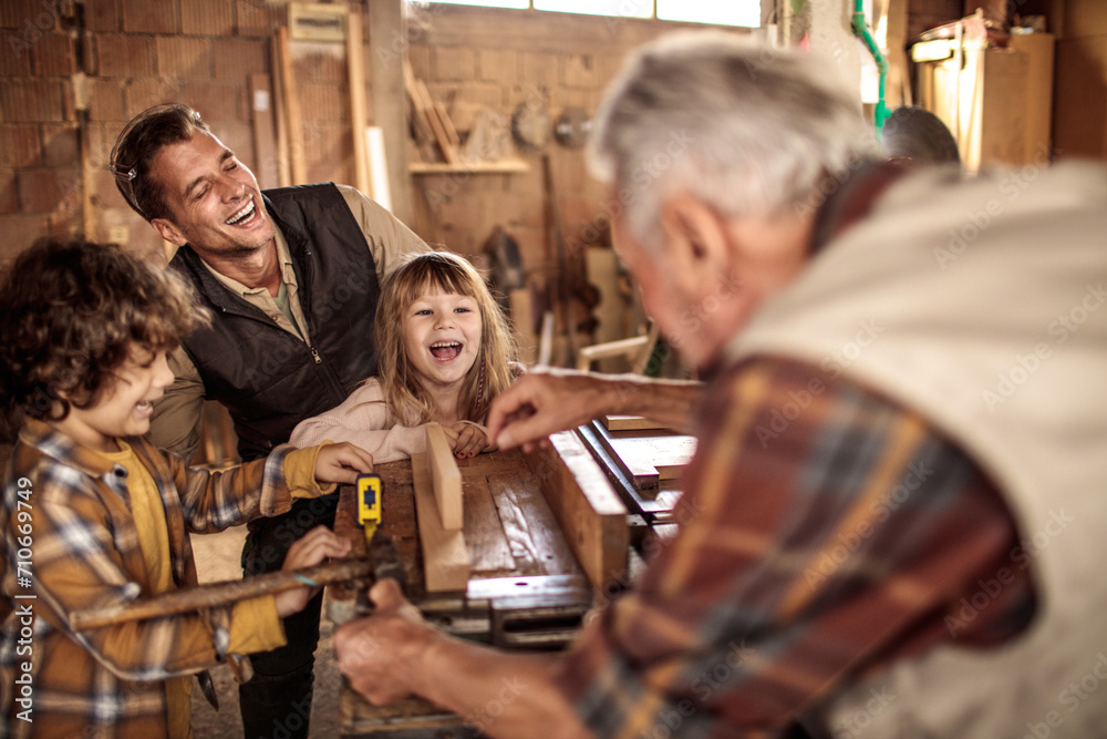 Happy family with children enjoying carpentry workshop together