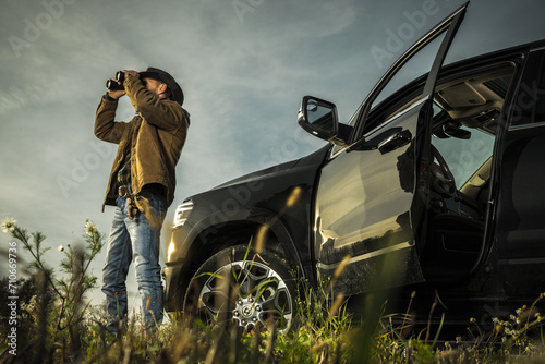 Land Owner Spotting Wildlife on His Ranch Using Binoculars