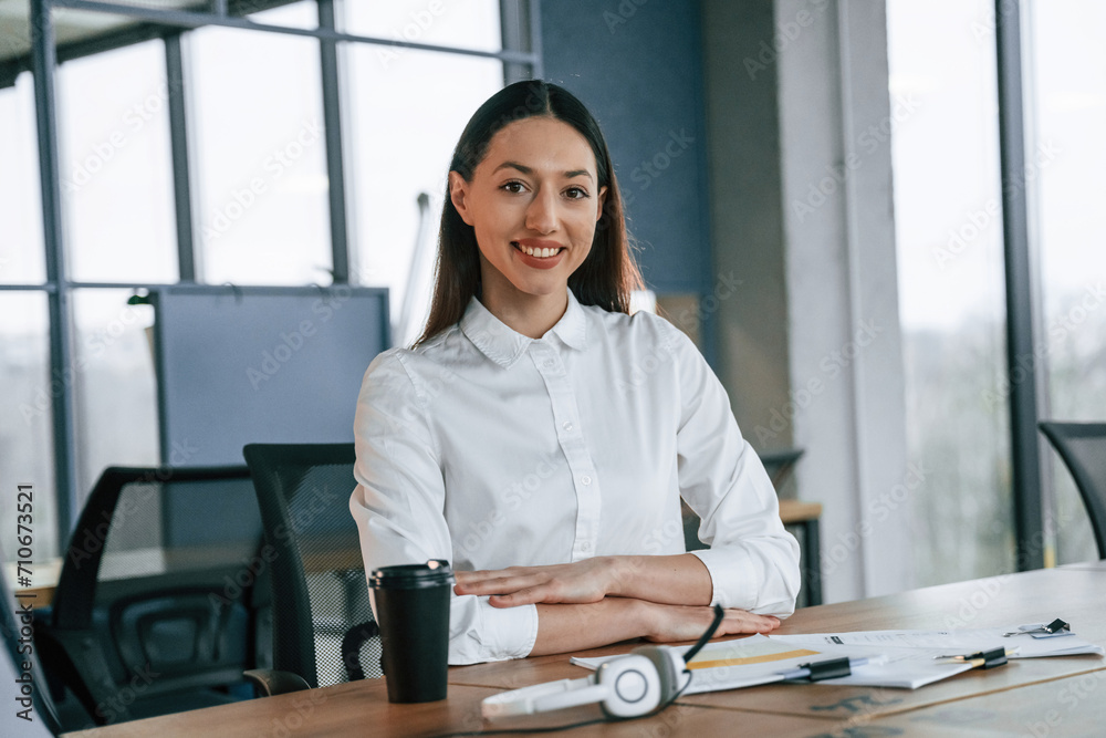 Smiling, taking a rest. Businesswoman is indoors in the office