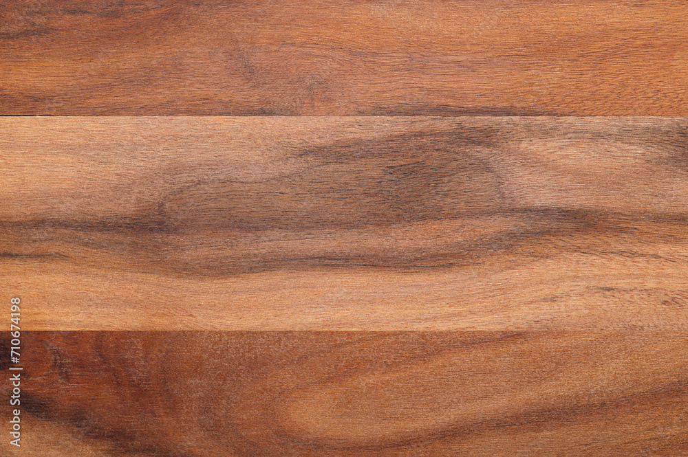 Surface of an olive wood board. Glued together dried boards of olive wood, cut parallel to its longitudinal axis. Very hard and tough material, used as kitchen cutting board. Close-up, from above. Surface of an olive wood board. Glued together dried boards of olive wood, cut parallel to its longitudinal axis. Very hard and tough material, used as kitchen cutting board. Close-up, from above.
