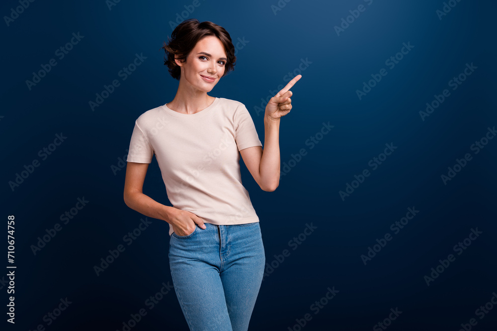 Portrait of pretty lady worker indicate finger side empty space wearing casual trendy clothes isolated on dark blue color background