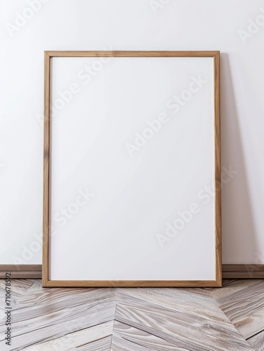 photo of a large blank frame leaning against a white wall.  Large framed art poster mockup on white wall.