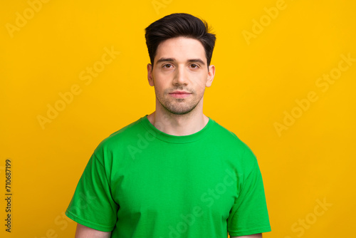 Photo portrait of handsome brunet hair tired worker guy wearing green t shirt confident person isolated over yellow color background