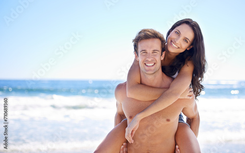 Portrait  piggy back and happy couple on beach for holiday adventure together on tropical island with blue sky. Smile  man and woman on ocean vacation with waves  love and mockup on travel in Hawaii.