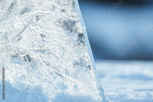 Tableau sur toile Transparent ice shard stands in a snowdrift on a sunny winter day
