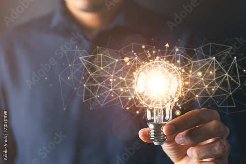 Businessman holding light bulb symbolizing creative idea and strategic thinking in business.Creative solution and idea concept. photo