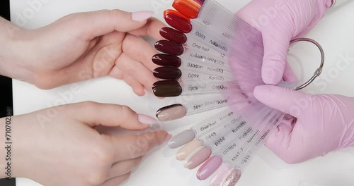 Client's choice of color for gel nail polish application in the salon. View from above, close up.