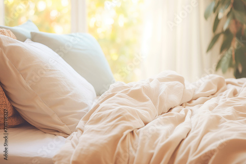 A photo of a neatly made bed with pillows, with a focus on the bedding and the rest of the bedroom gently blurred