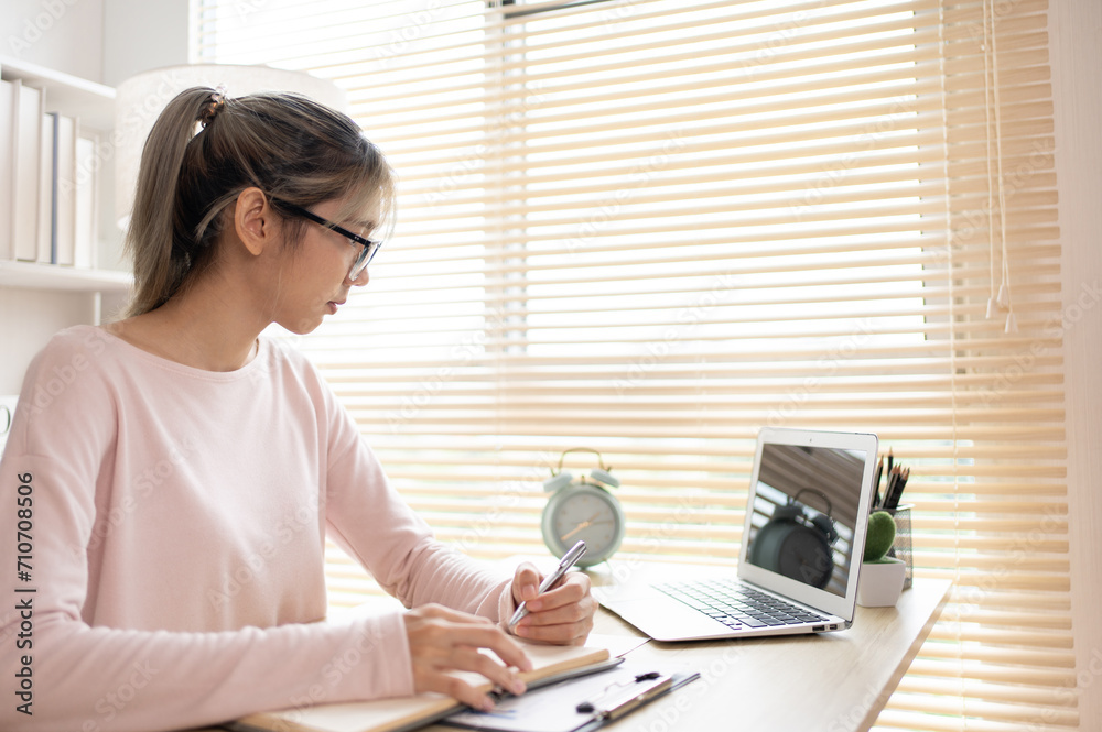 Studying online using a laptop, Learn online, Take notes of important conversations and messages during the teacher's teaching.