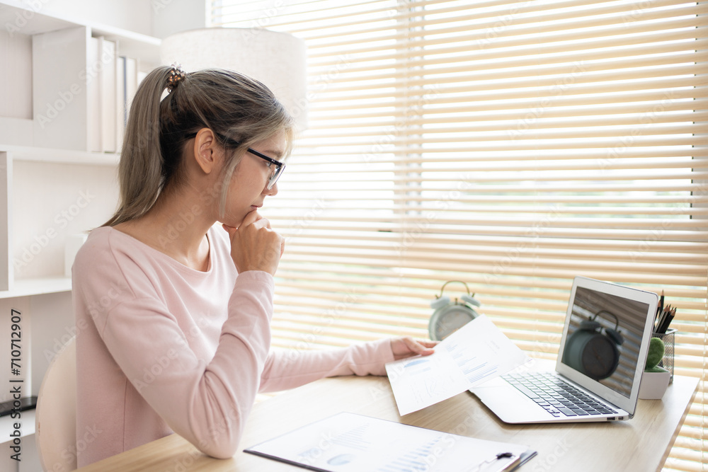 Thinking, Businesswoman analyzes data graphs and works intently in his personal office, Employees working in the office, Businesswoman at Desk. Thinking, Businesswoman analyzes data graphs and works intently in his personal office, Employees working in the office, Businesswoman at Desk.