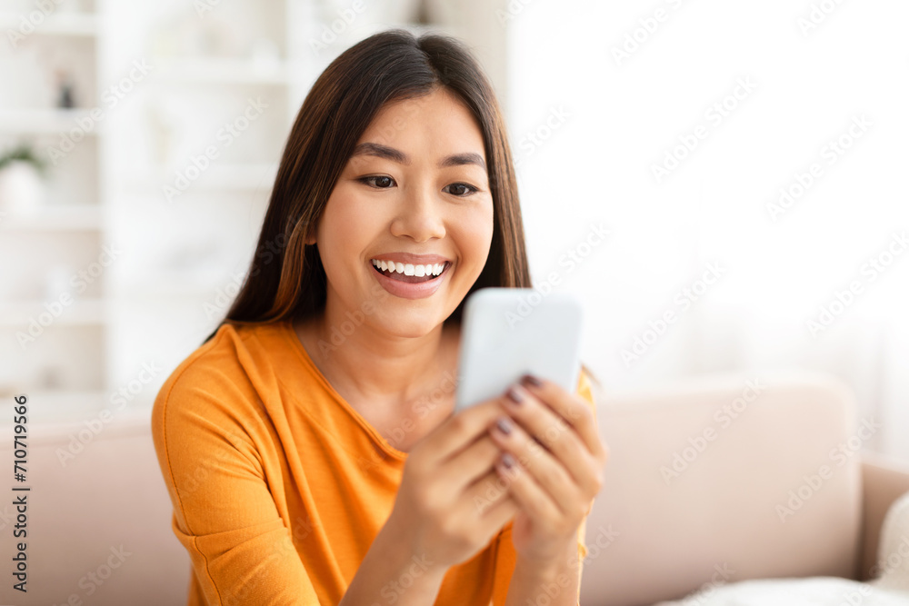 Closeup of smiling young asian woman using smartphone at home, Closeup of smiling young asian woman using smartphone at home,