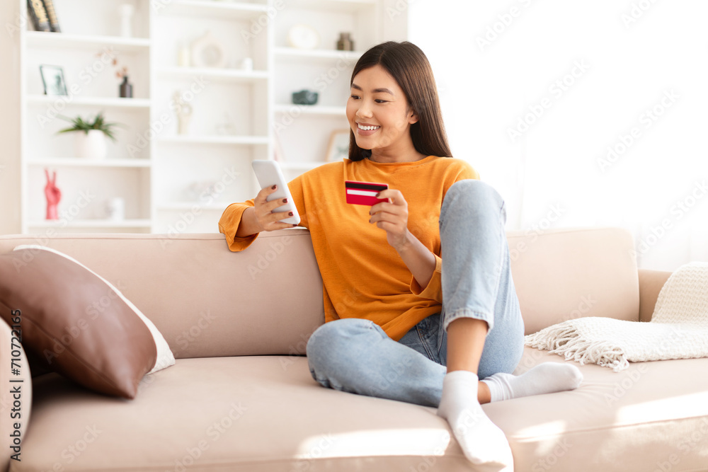 Cheerful chinese lady make online order while resting at home Cheerful chinese lady make online order while resting at home