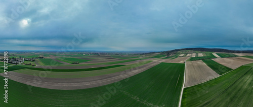 Panoramic aerial view of farmland with hills and a forest in the distance on a cloudy day, Stockerau, Lower Austria, Austria. photo