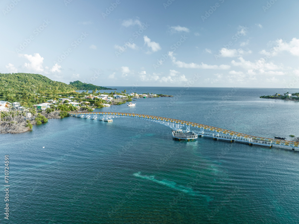 Aerial view of a suspended bridge crossing the bay connecting the two islands Providencia and Santa Catalina Island, Archipelago of Saint Andrew, Colombia. Aerial view of a suspended bridge crossing the bay connecting the two islands Providencia and Santa Catalina Island, Archipelago of Saint Andrew, Colombia.