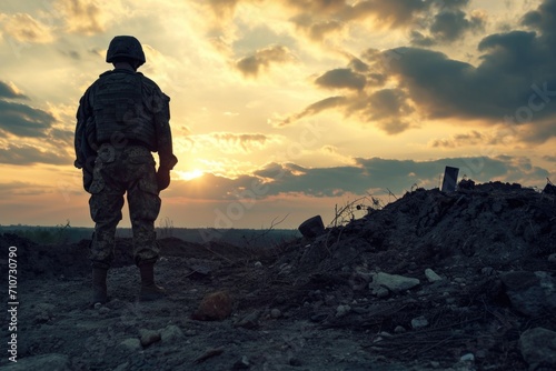 Silhouette of a soldier in a military uniform at sunset. © Владимир Солдатов