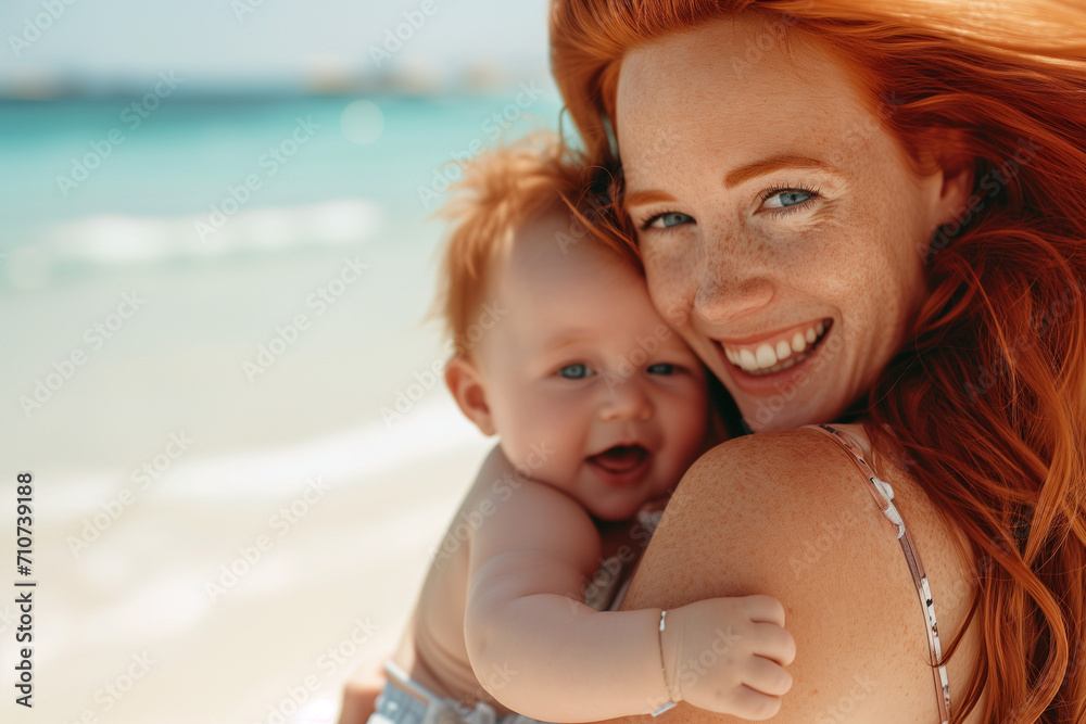 Happy redhead woman holding her baby in a beautiful beach