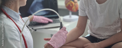 Doctor conducts ultrasound examination of patient child wrist photo