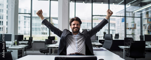 Successful businessman celebrating success and raising hands up photo