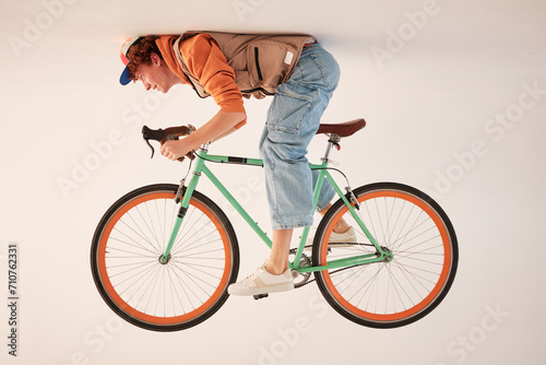 studio portrait of a red-haired young stylish sporty man with a bicycle