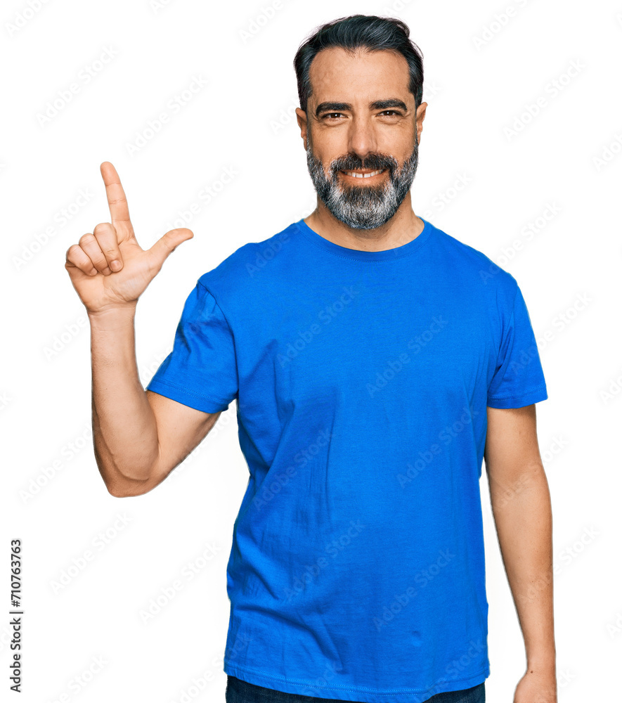 Middle aged man with beard wearing casual blue t shirt showing and pointing up with fingers number two while smiling confident and happy. Middle aged man with beard wearing casual blue t shirt showing and pointing up with fingers number two while smiling confident and happy.