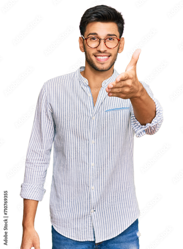 Young handsome man wearing casual clothes and glasses smiling friendly offering handshake as greeting and welcoming. successful business. Young handsome man wearing casual clothes and glasses smiling friendly offering handshake as greeting and welcoming. successful business.