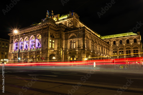 Wiener Staatsoper bei Nacht mit Langzeitbelichtung des Verkehrs im Vordergrund.