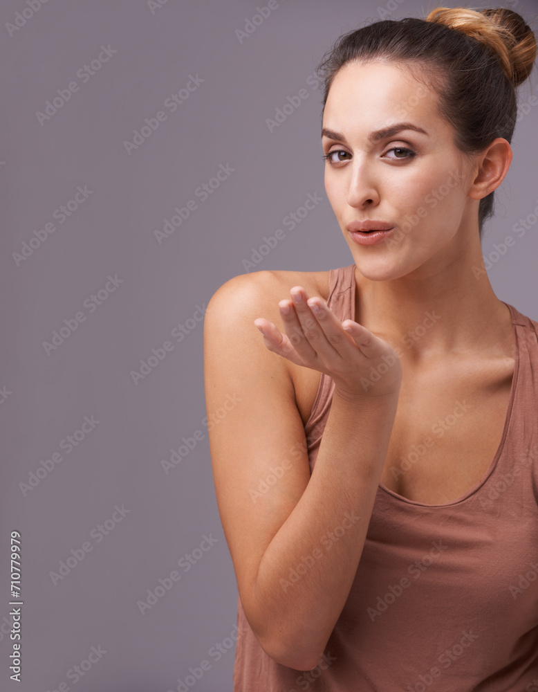 Portrait of woman, blow kiss or skincare with beauty or cosmetics for healthy glow or results. Isolated, flirting or confident model with natural shine or wellness in studio on purple background Portrait of woman, blow kiss or skincare with beauty or cosmetics for healthy glow or results. Isolated, flirting or confident model with natural shine or wellness in studio on purple background