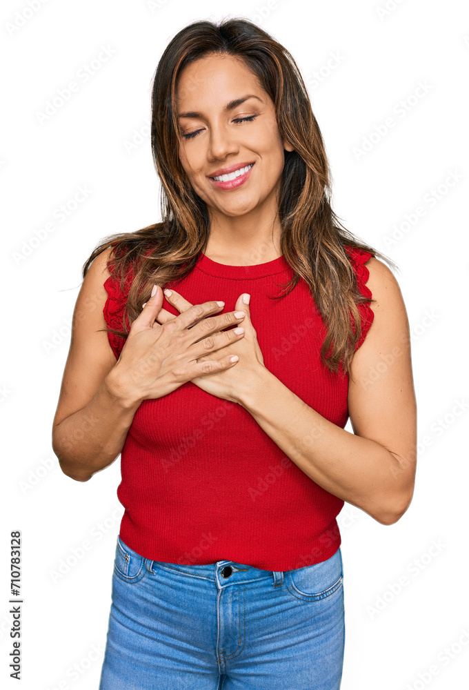 Young hispanic woman wearing casual clothes smiling with hands on chest with closed eyes and grateful gesture on face. health concept. Young hispanic woman wearing casual clothes smiling with hands on chest with closed eyes and grateful gesture on face. health concept.