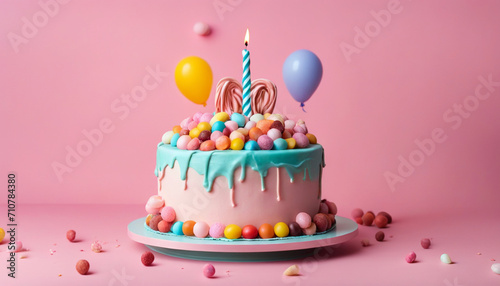 Birthday cake decorated with colorful sweets  balloons on a pink background. Birthday concept