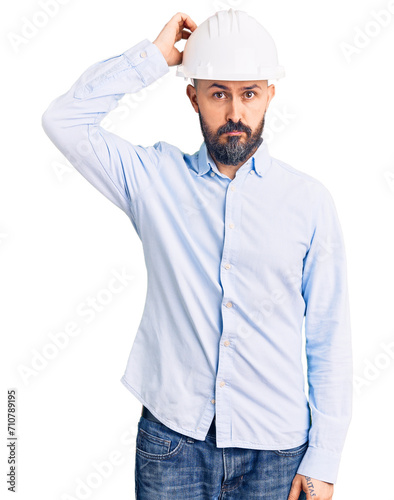 Принти на полотні Young handsome man wearing architect hardhat confuse and wonder about question