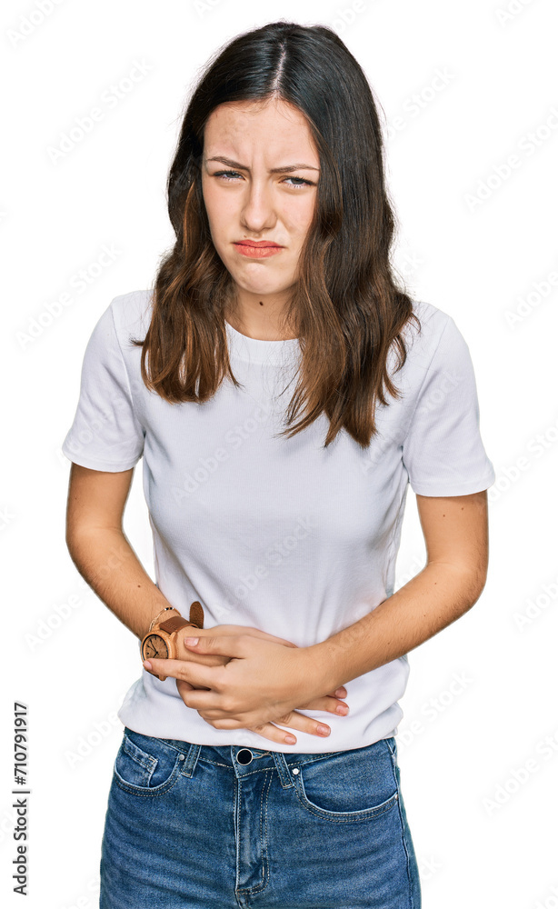 Young beautiful woman wearing casual white t shirt with hand on stomach because indigestion, painful illness feeling unwell. ache concept. Young beautiful woman wearing casual white t shirt with hand on stomach because indigestion, painful illness feeling unwell. ache concept.