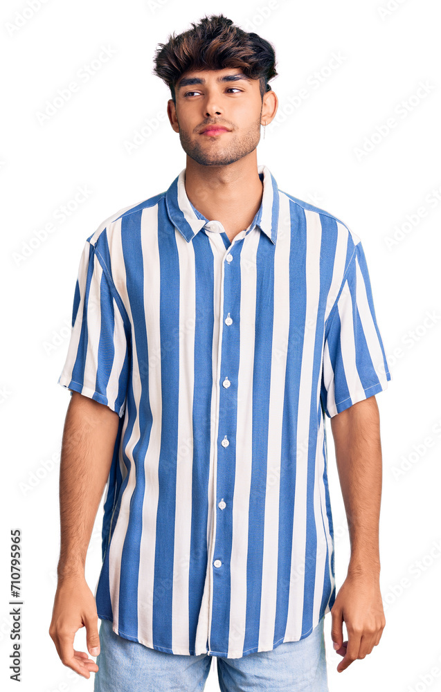 Young hispanic man wearing casual clothes smiling looking to the side and staring away thinking.