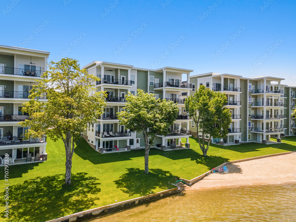 a resort building near the water with several units on each floor and lawn, Lakeport New Hampshire.