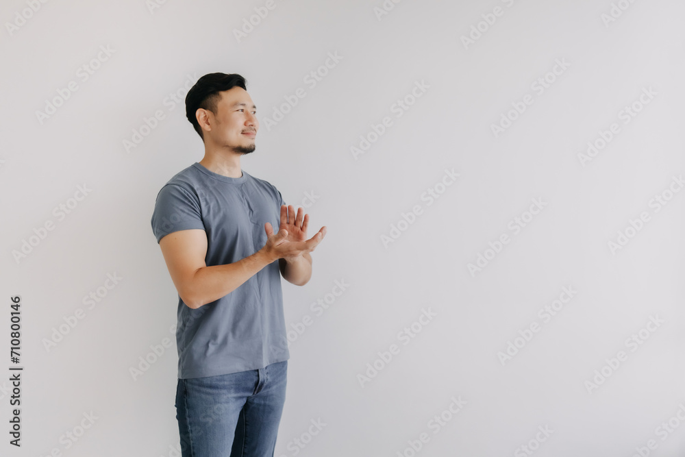 Happy asian man in blue t-shirt and jeans clapping hands stand isolated on white Happy asian man in blue t-shirt and jeans clapping hands stand isolated on white