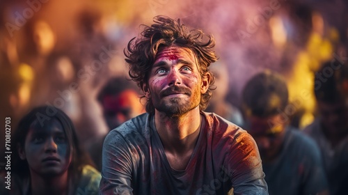 Man With Red Paint on Face Sitting in Front of Crowd of People, Holi
