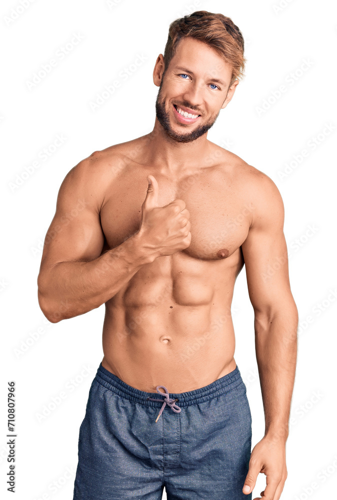 Young caucasian man standing shirtless doing happy thumbs up gesture with hand. approving expression looking at the camera showing success.
