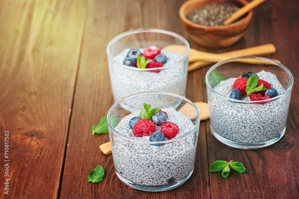Chia pudding with fresh berries raspberries, blueberries. Side view, three glass