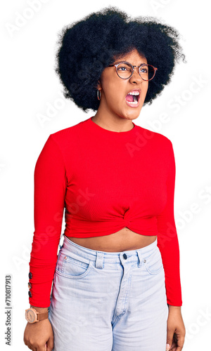 Young african american girl wearing casual clothes and glasses angry and mad screaming frustrated and furious, shouting with anger. rage and aggressive concept.