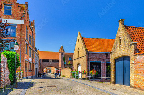 Bruges cityscape with buildings of Art Gallery Koetshuis and Zonnekemeers Gate with brick walls in Brugge city historical centre, Bruges old town quarter medieval district, Flemish Region, Belgium © Aliaksandr