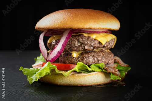 Hamburger on a black background with olives and fera cheese