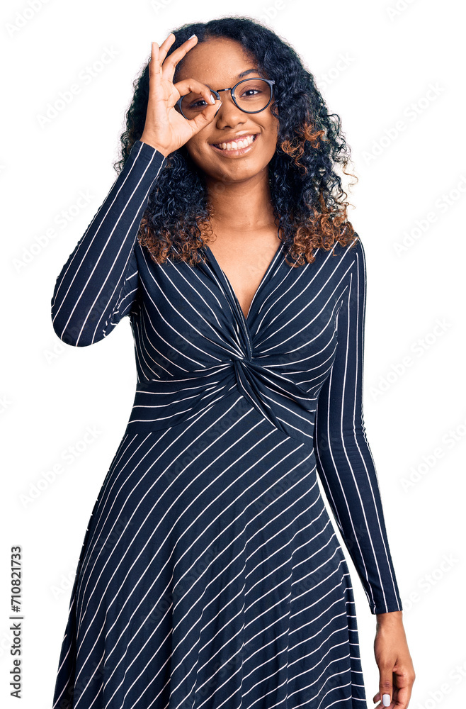 Young african american woman wearing casual clothes and glasses doing ok gesture with hand smiling, eye looking through fingers with happy face. Young african american woman wearing casual clothes and glasses doing ok gesture with hand smiling, eye looking through fingers with happy face.