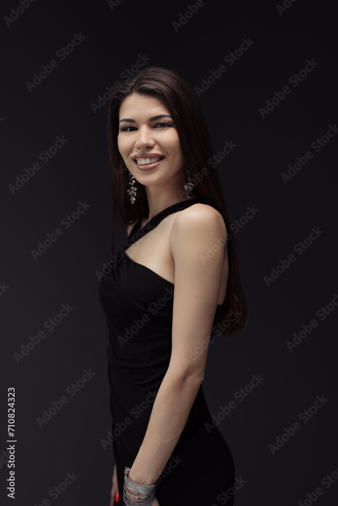 A woman elegantly poses in a classic black dress, ready to be captured in a memorable photograph. A woman elegantly poses in a classic black dress, ready to be captured in a memorable photograph.